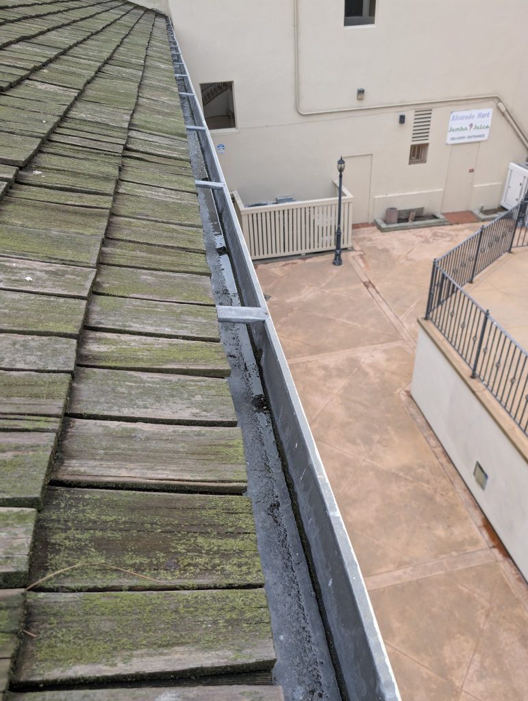 Gutter cleaning on a wood shingle roof