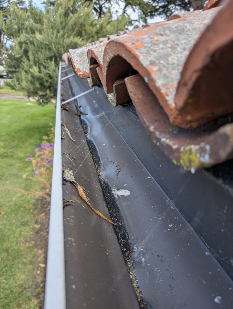 Gutter cleaning on a clay tile roof