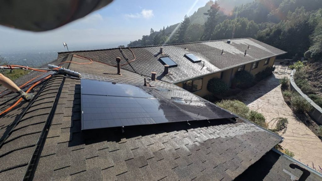 California Glass and Solar technician cleaning solar panels on a roof